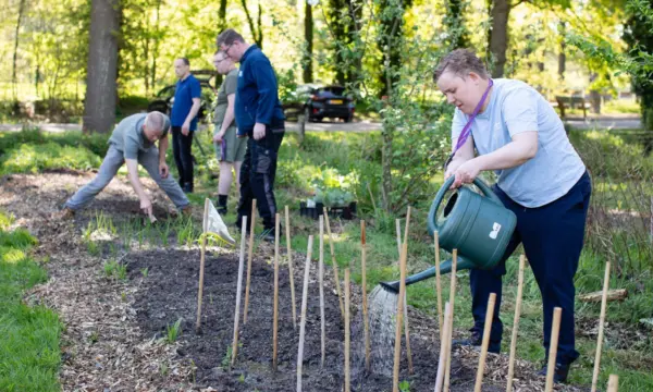 Cliënten aan het werk in een tuin