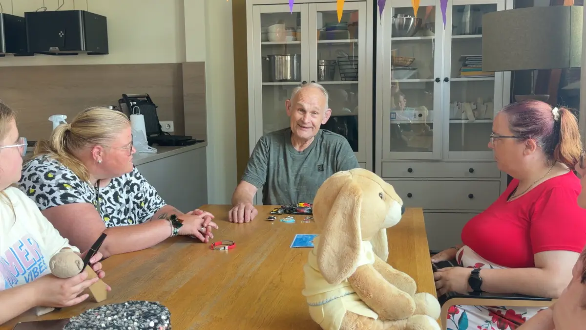 Cliënten zitten gezellig samen aan tafel