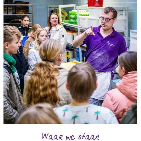 Een groep mensen staat in een keuken waar iemand in een Philadelphia-shirt iets uitlegt